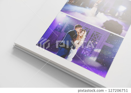 the pages of a photo book with wedding photos.  127206751