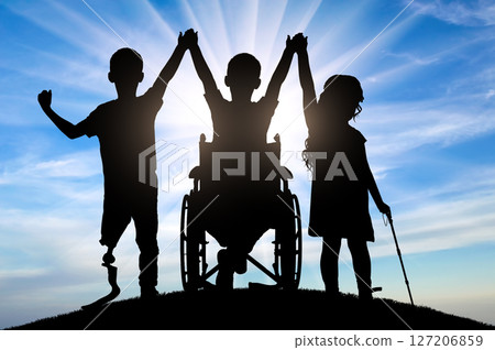 Silhouettes of three children with different disabilities standing together holding hands Silhouettes of three children with different disabilities standing together holding hands 127206859