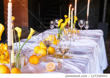 moscow, russia, 22.05.2025 A table with a white tablecloth and yellow flowers and lemons moscow, russia, 22.05.2025 A table with a white tablecloth and yellow flowers and lemons 127206943