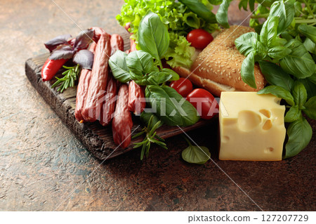 Thin smoked sausages with cheese, bread, and greens. Thin smoked sausages with cheese, bread, and greens. 127207729