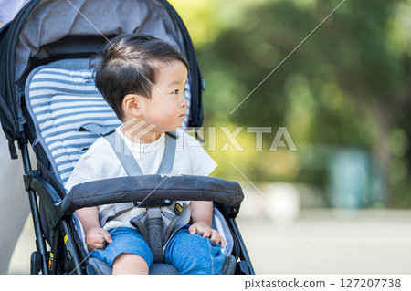 一個男孩坐在嬰兒車裡。 127207738