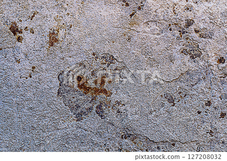 Background of light beige metal wall, from which layers of excess hardened cement mortar are breaking off, and the exposed areas are covered with brown, deep rust. Properties of Structural Materials 127208032