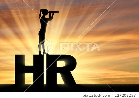 Silhouette of a woman standing on the letters HR and looking through binoculars. Hiring concept 127208258
