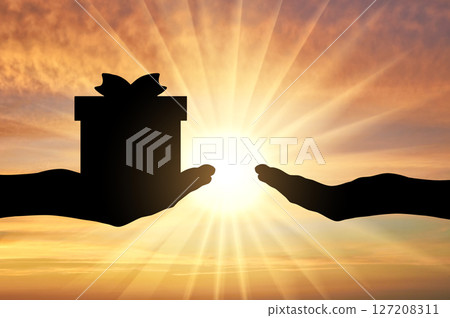 Silhouette of a hand giving a gift and a hand receiving a gift Silhouette of a hand giving a gift and a hand receiving a gift 127208311