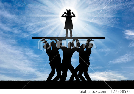 Childish selfishness. A crowd of people is holding a selfish child girl with a crown on her head on a pedestal 127208524