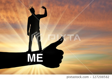 Selfishness and narcissism. A selfish man with a crown on his head points his finger at himself. 127208582
