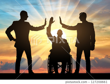 Empowering Teamwork: Silhouetted businesspeople supporting a person in a wheelchair at sunset Empowering Teamwork: Silhouetted businesspeople supporting a person in a wheelchair at sunset 127208661