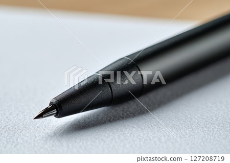 Closeup of a Black Stylus on Paper. Closeup of a Black Stylus on Paper. 127208719