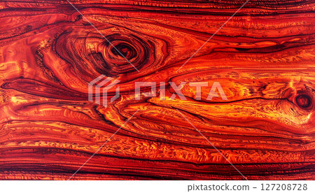 wood texture background, mahogany wood texture, showcasing its rich reddish brown color and seamless grain pattern. This luxurious wood surface features elegant, swirling natural lines 127208728