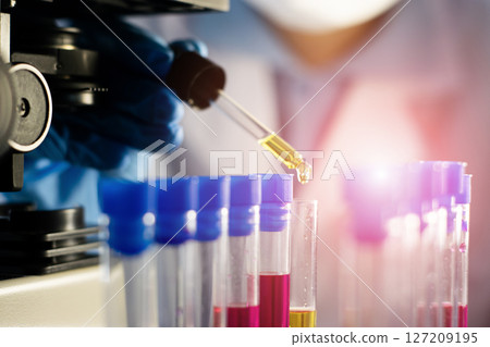 Scientist doing chemical experiment in laboratory with flask of liquid. Concept of science research, chemistry study and laboratory investigation. 127209195