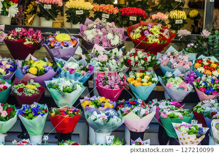 Colorful flower bouquets in paper wraps displayed at a vibrant flower market. High quality photo Colorful flower bouquets in paper wraps displayed at a vibrant flower market. High quality photo 127210099