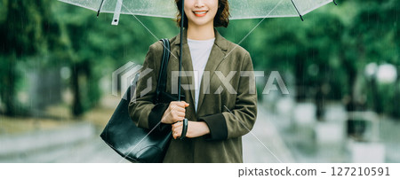 A woman holding an umbrella in the rain (rainy season, June) 127210591