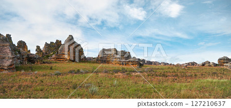 Low grass growing on African savanna, small rocky mountains in background - typical scenery at Isalo national Park, Madagascar 127210637