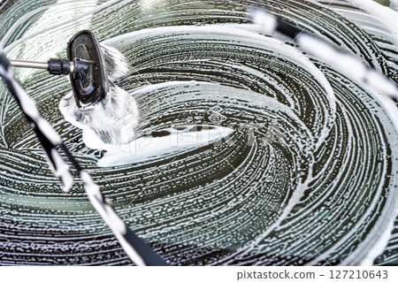 Front wind shield of a car washed in self serve carwash, brush leaving white strokes of soap on glass Front wind shield of a car washed in self serve carwash, brush leaving white strokes of soap on glass 127210643