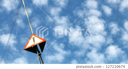 Red triangle with exclamation mark on steel cable of electric pylon, fluffy sky in background - wide photo, space for text right side Red triangle with exclamation mark on steel cable of electric pylon, fluffy sky in background - wide photo, space for text right side 127210674