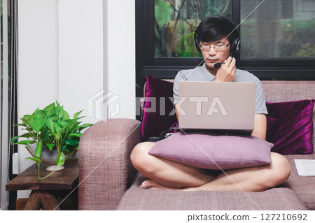 Businessman meeting online via video call on laptop in home office. Man wear headphone video calling or distance education e-leaning online course. Businessman meeting online via video call on laptop in home office. Man wear headphone video calling or distance education e-leaning online course. 127210692