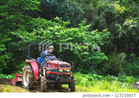 Young man plowing the field with a tractor Young man plowing the field with a tractor 127210857