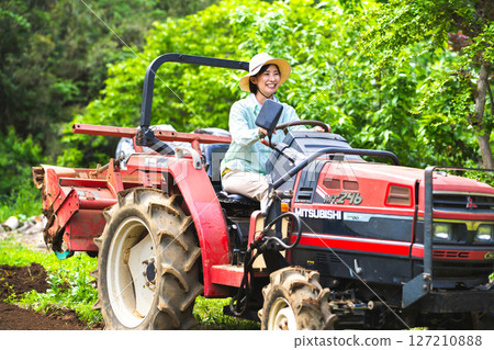 Woman plowing the field with a tractor Woman plowing the field with a tractor 127210888