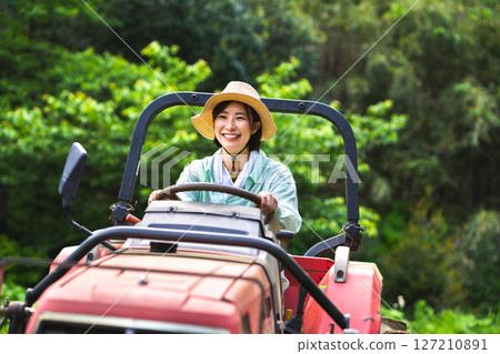 Woman plowing the field with a tractor Woman plowing the field with a tractor 127210891