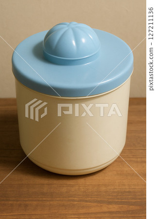 Plastic Food Container with Blue Lid on Wooden Table  Minimalist Home Storage Concept 127211136