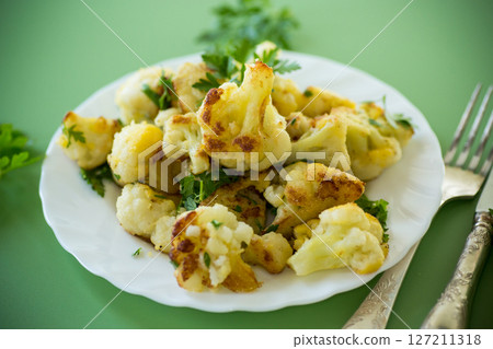 Rustic vegetable dish with cabbage and herbs on a green background 127211318
