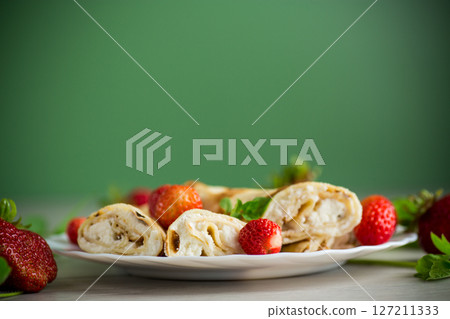 Pancakes with tender cottage cheese and fresh strawberries 127211333