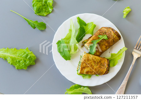 Healthy egg roll with greens on a white plate 127211357