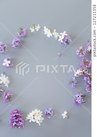 Lilac bouquet from above on a minimalistic gray background for design 127211358