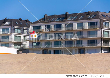 Wooden model of a house with a red roof on a pole on a sandy beach, coastal village De Haan, West Flanders, Belgium Wooden model of a house with a red roof on a pole on a sandy beach, coastal village De Haan, West Flanders, Belgium 127212065