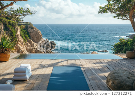 Idyllic scene of wooden deck with swimming pool and ocean view. Workout mat is laid out on the deck. 127212271