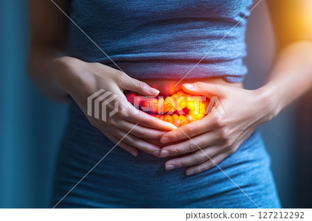Woman touching her stomach with her hands in the intestinal area in a fit of pain. Intestinal inflammation. Concept of intestinal disease 127212292