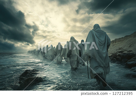 Pilgrims in cloaks with walking sticks walk along the road between the mountain and the sea. 127212395