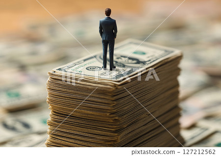 Finance and business concept. Man standing on a stack of dollars. Finance and business concept. Man standing on a stack of dollars. 127212562
