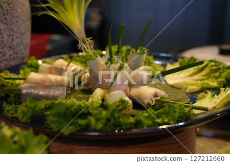 Spring rolls lettuce rice paper rolls Tourists prepare and eat spring roll with rice paper wrapper or banh trang at night streetfood market. Traditional Vietnamese nem dish, asian cuisine. Close up 127212660