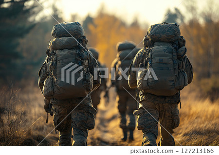 Men in military uniform carrying large backpacks walk home through the forest on a sunny day. Generated by artificial intelligence 127213166