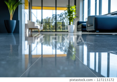 Reflection of the office hall interior on a clean marble floor. Blurred interior of an office hallway with large windows and comfortable chairs. 127213172