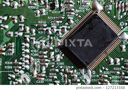 A microchip soldered on an intricate green electronic circuit board A microchip soldered on an intricate green electronic circuit board 127213388