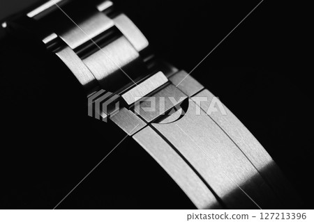 Elegant closeup of a metal watch bracelet buckle in monochrome view 127213396