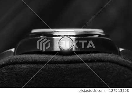 A detailed black and white view of a luxury wristwatch crown 127213398