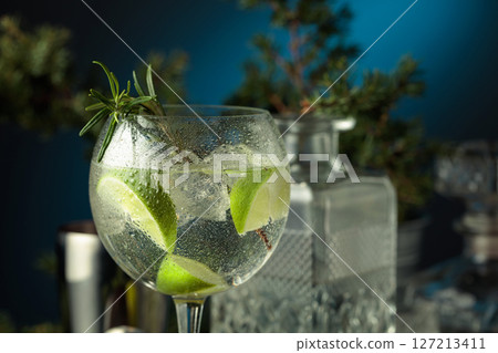 Cocktail gin and tonic with ice and lime slices in wet glass. Cocktail gin and tonic with ice and lime slices in wet glass. 127213411