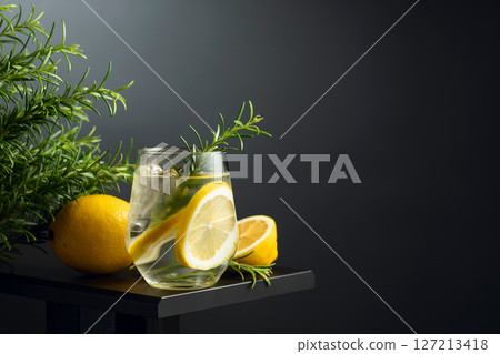 Refreshing drink with ice, lemon slices, and rosemary. 127213418
