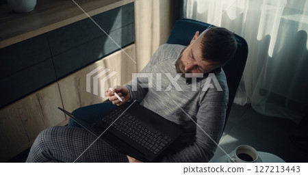 High Angle of Businessman Having Phone Call, Working on Laptop, Monitoring Real-Time Stocks High Angle of Businessman Having Phone Call, Working on Laptop, Monitoring Real-Time Stocks 127213443