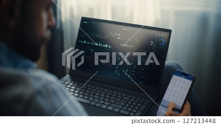 Close Up of Stock Trader Monitoring Real-Time Stocks in Trading App Using Smartphone and Laptop Close Up of Stock Trader Monitoring Real-Time Stocks in Trading App Using Smartphone and Laptop 127213448