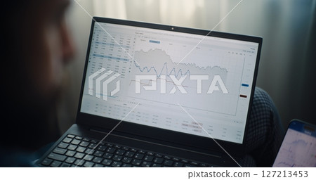 Close Up of Stock Exchange Broker Using Laptop and Smartphone, Monitoring Stocks in Trading Software Close Up of Stock Exchange Broker Using Laptop and Smartphone, Monitoring Stocks in Trading Software 127213453