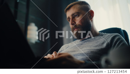 Successful Businessman Working on Laptop, Monitoring Real-Time Stocks, Drinking Coffee 127213454