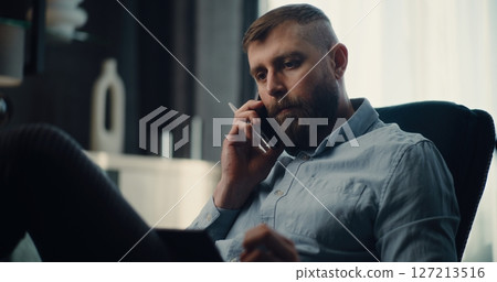 Financial Analyst Talking on Phone, Monitoring Real-Time Stocks on Tablet Computer 127213516