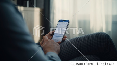 Close Up of Businessman Working on Smartphone, Monitoring Real-Time Stocks in Online Trading App Close Up of Businessman Working on Smartphone, Monitoring Real-Time Stocks in Online Trading App 127213528