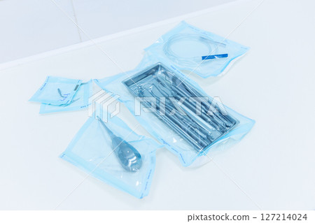 A Collection of Sterile Medical Instruments Carefully Arranged in Packaging on a Clean Surface for Surgical Use in a Medical Environment 127214024