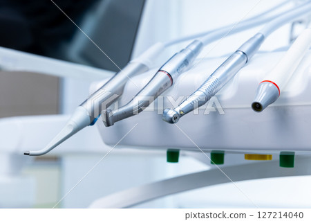 An Array of Precision Dental Instruments Displayed on a Dental Chair in a Modern Clinic, Showcasing Essential Tools for Oral Health Care and Dental Procedures 127214040