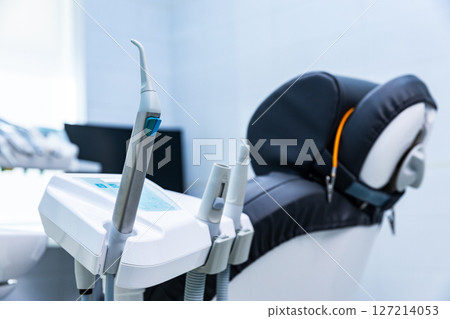 Modern dental equipment in a clinic setting showcasing advanced instruments and a comfortable patient chair prepared for treatment in a bright, clean environment Modern dental equipment in a clinic setting showcasing advanced instruments and a comfortable patient chair prepared for treatment in a bright, clean environment 127214053